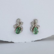 Goldene Ohrringe in Form einer Schleife mit Smaragden